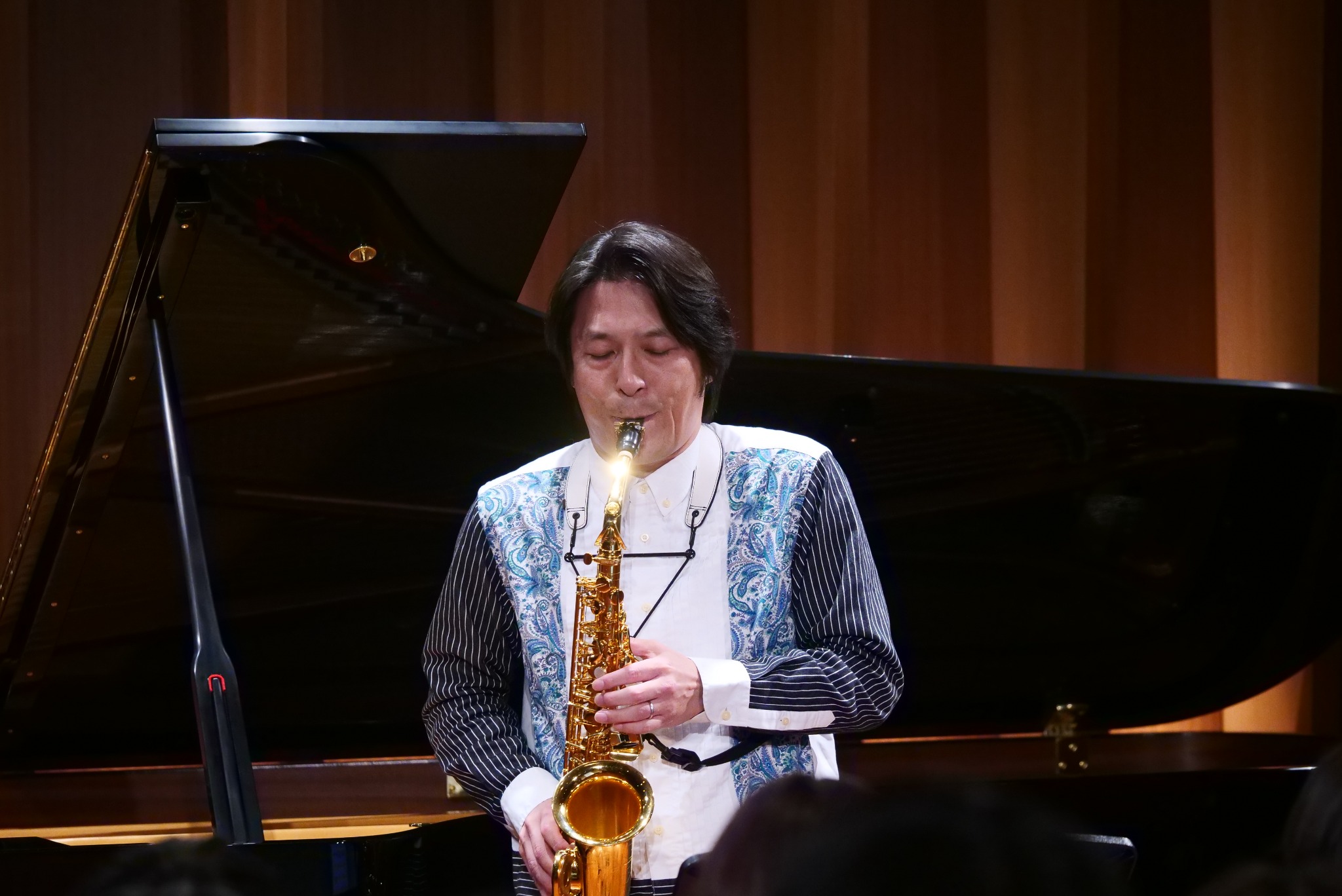 ステージでサクソフォンを演奏する國末貞仁